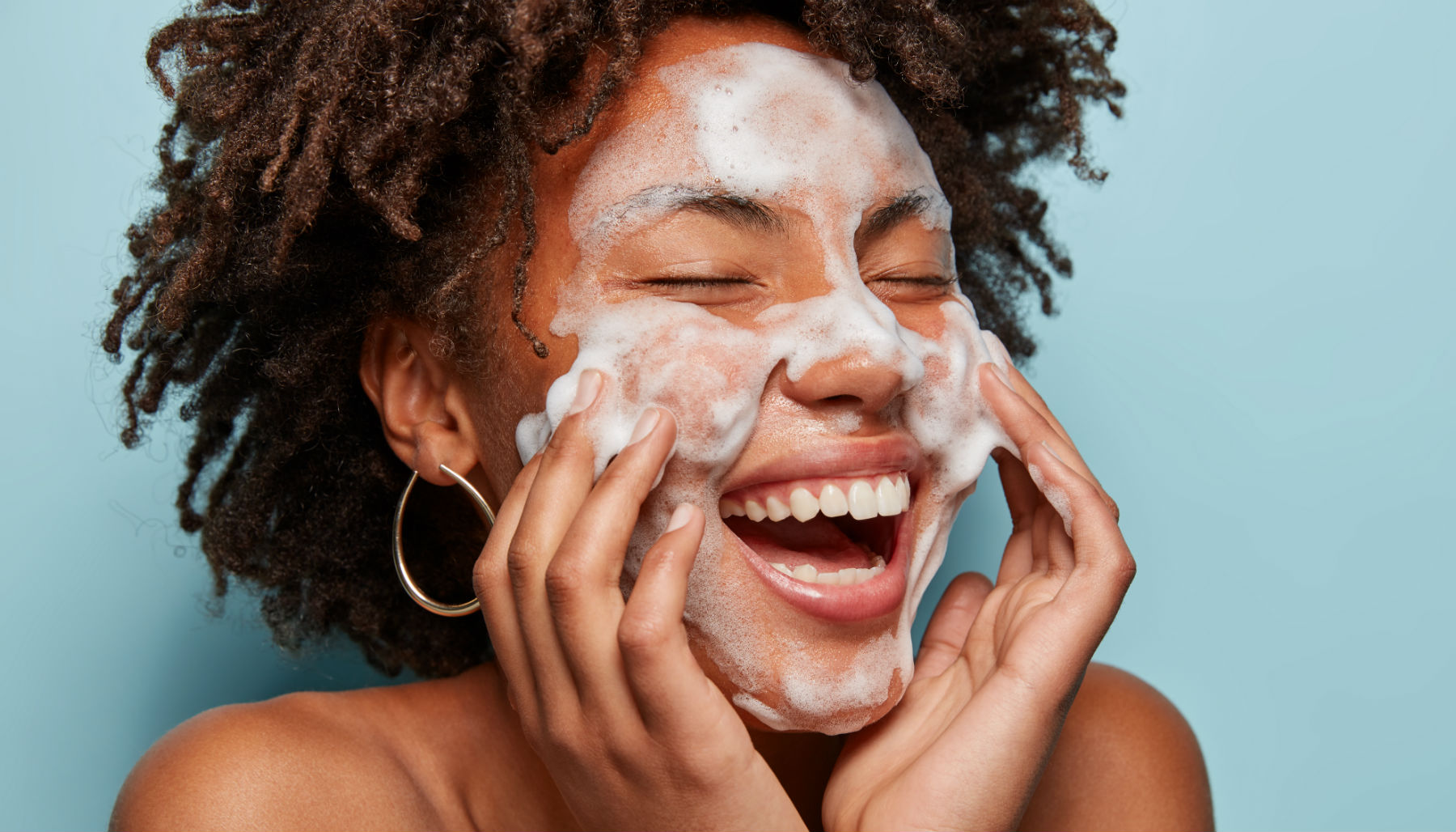 woman with foaming cleanser on her face