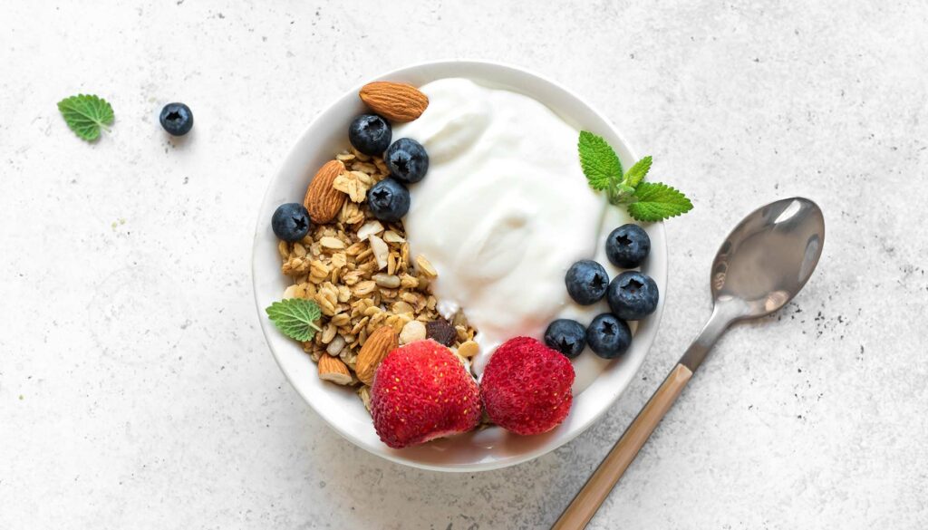 aerial shot of a bowl filled with yogurt, fruit, and granola