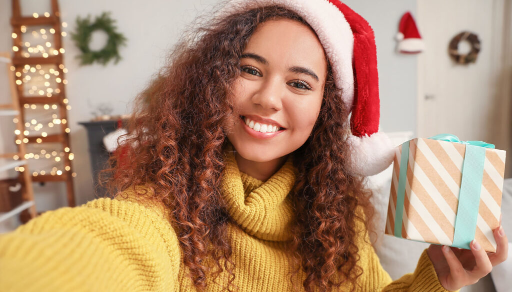 A festive young woman takes a selfie with a gift to say thank you