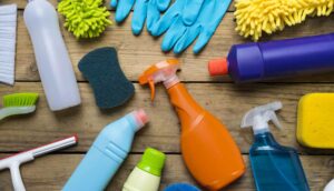 assorted cleaning products and tools on a wood surface, aerial view
