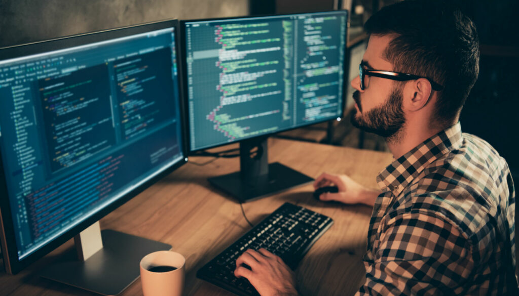 man working at two screens