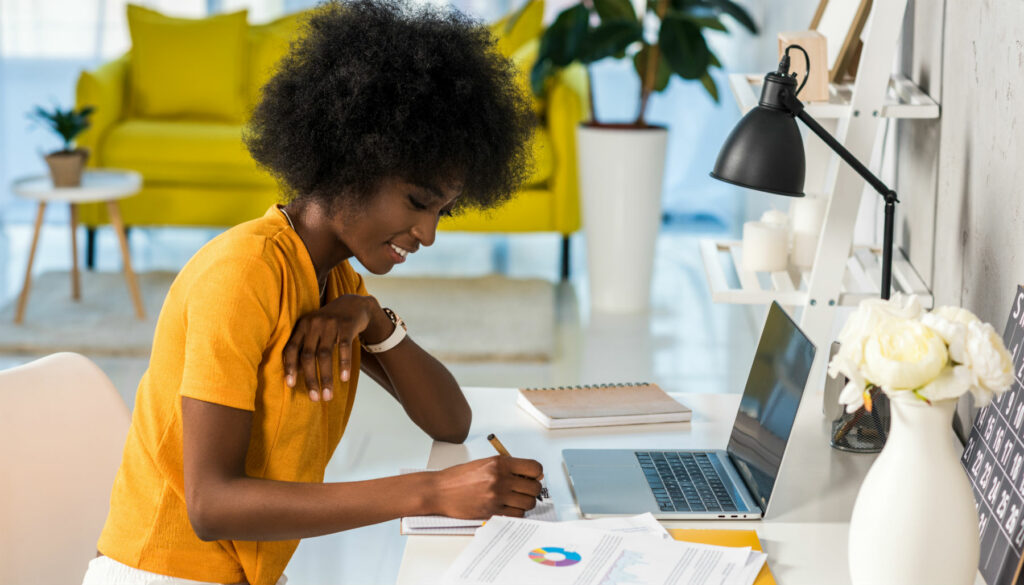 woman-writing-in-notebook-at-desk