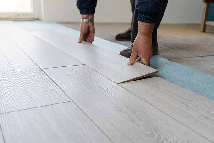 person installing plank vinyl flooring tile