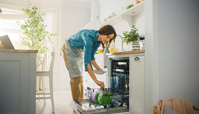 woman putting dishes into the dishwasher