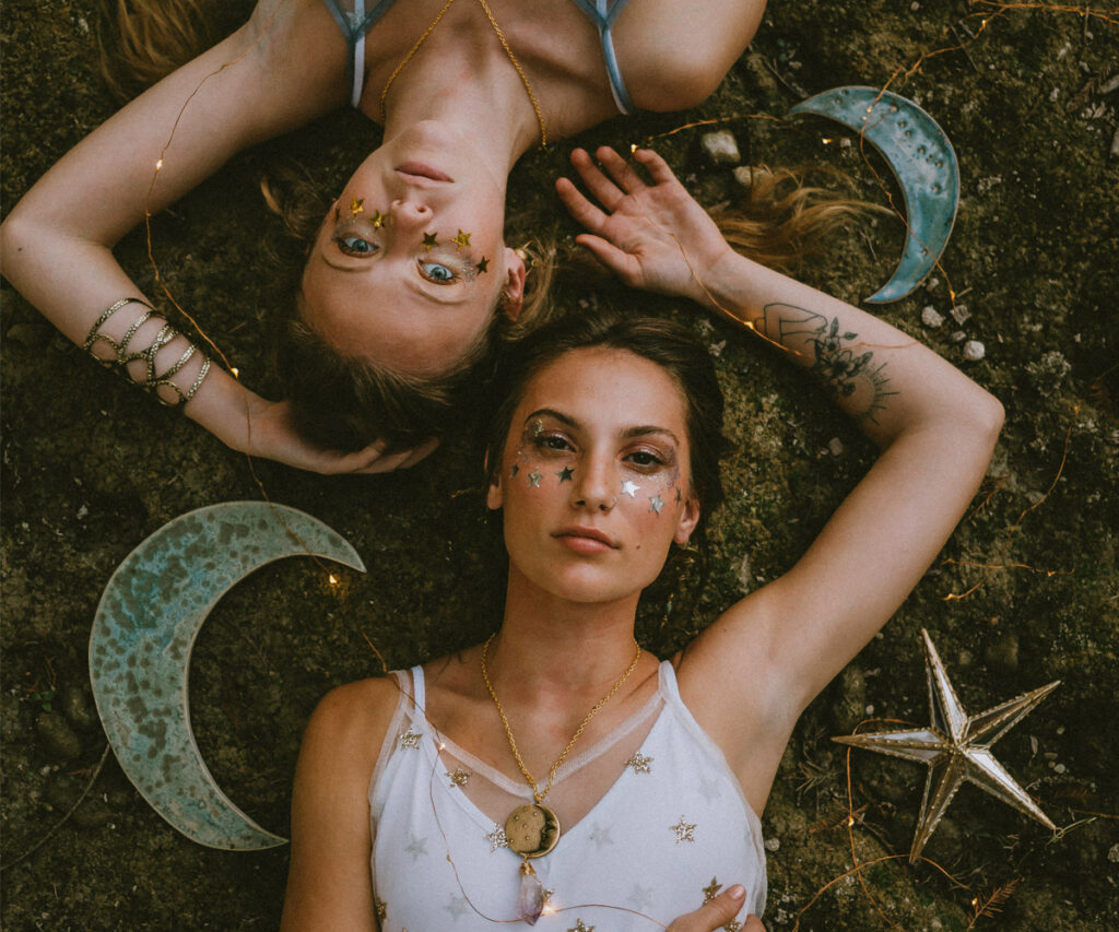 Women lying on ground wearing whimsical jewelry