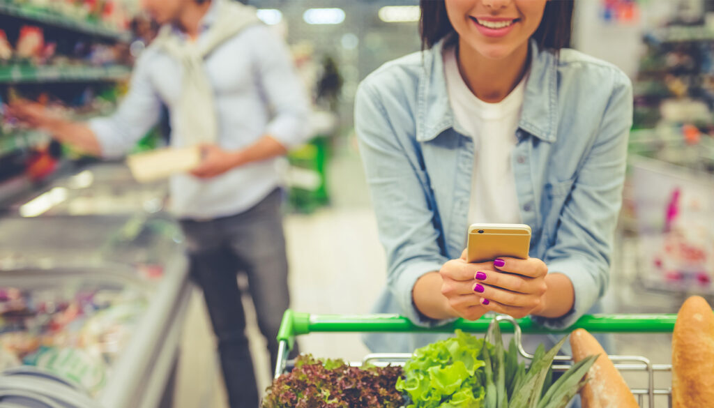 woman-grocery-shopping-and-checking-phone
