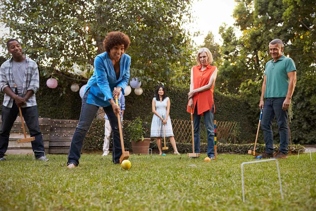 friends playing croquet in the back yard