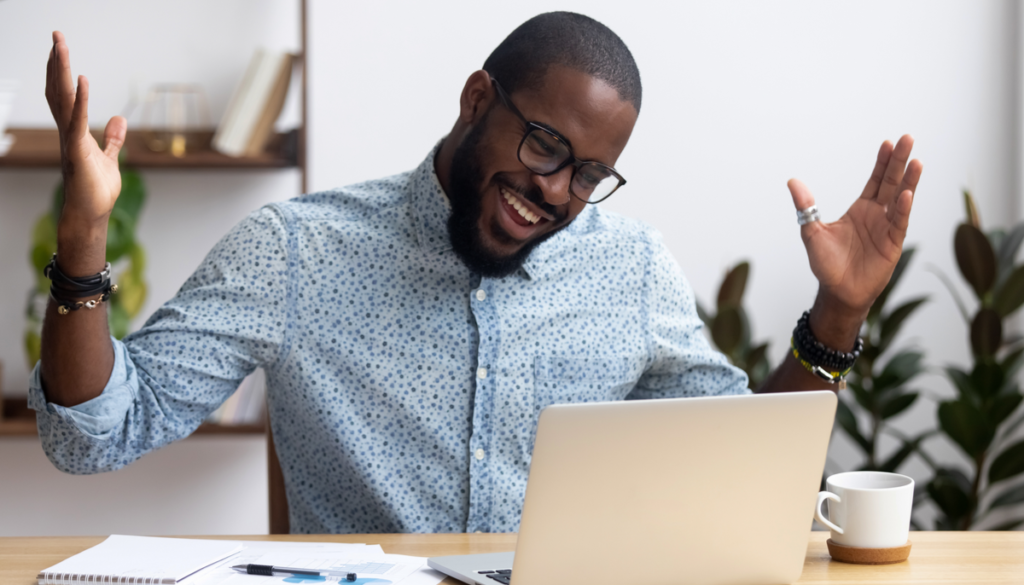 joyful man smiling at his computer screen