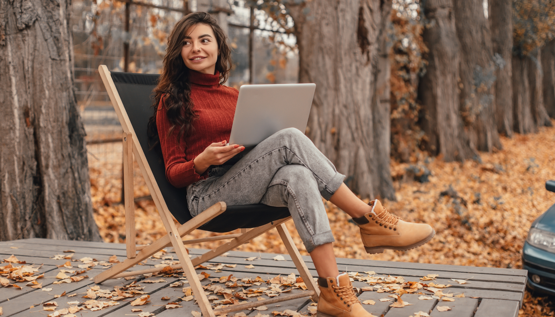 Woman working on laptop outside in fall