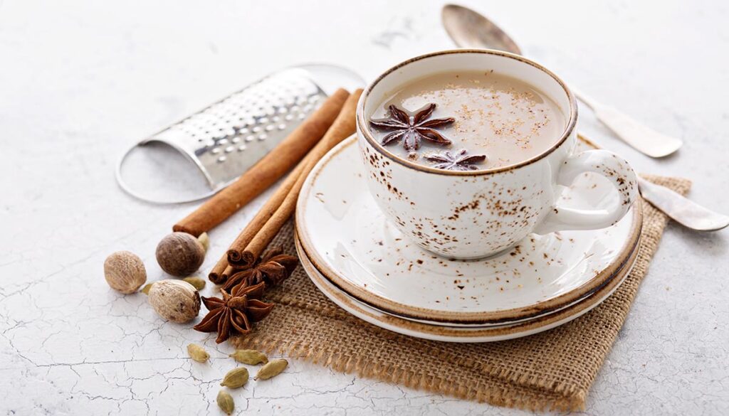 Warm chai tea with milk and winter spices in a ceramic cup