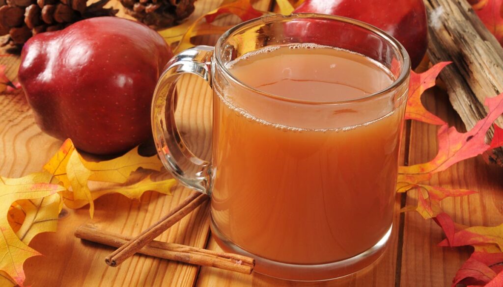 A cup of hot apple cider on an autumn table setting