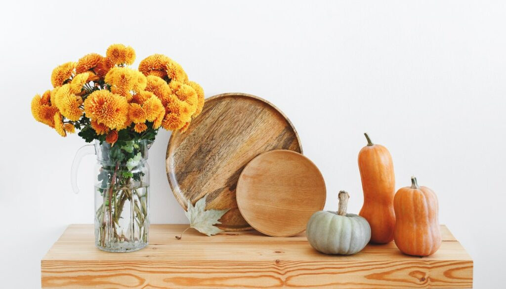 flowers pumpkins on wood table