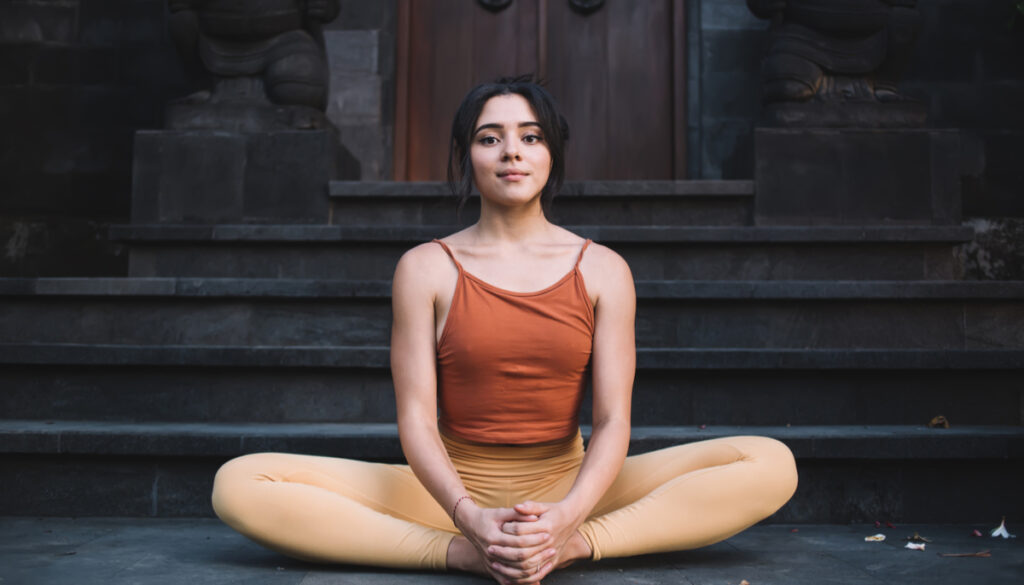 Woman in Yoga pose Bhadrasana (Butterfly Pose)