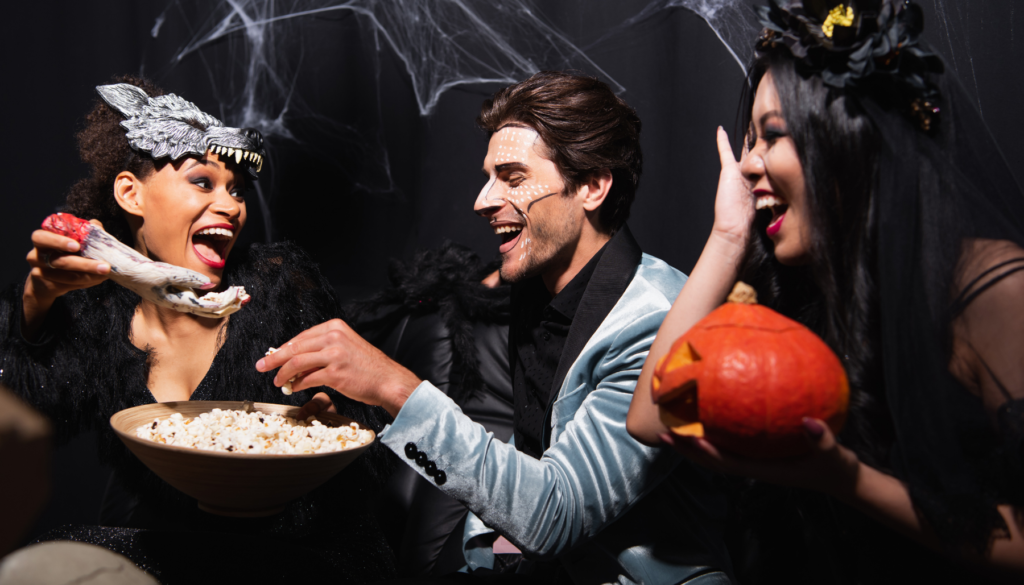 Young women and man laughing at Halloween party