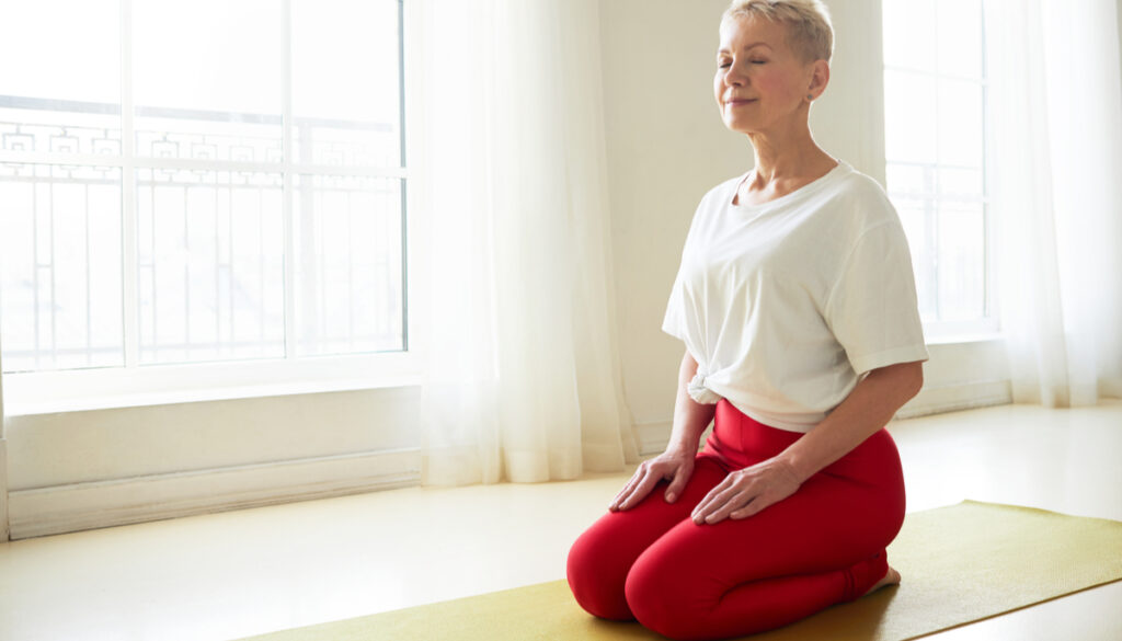 Woman in Yoga Pose Virasana (Hero's Pose)