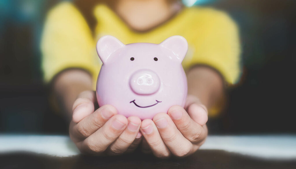 Female hand holding piggy bank. Save money and financial investment
