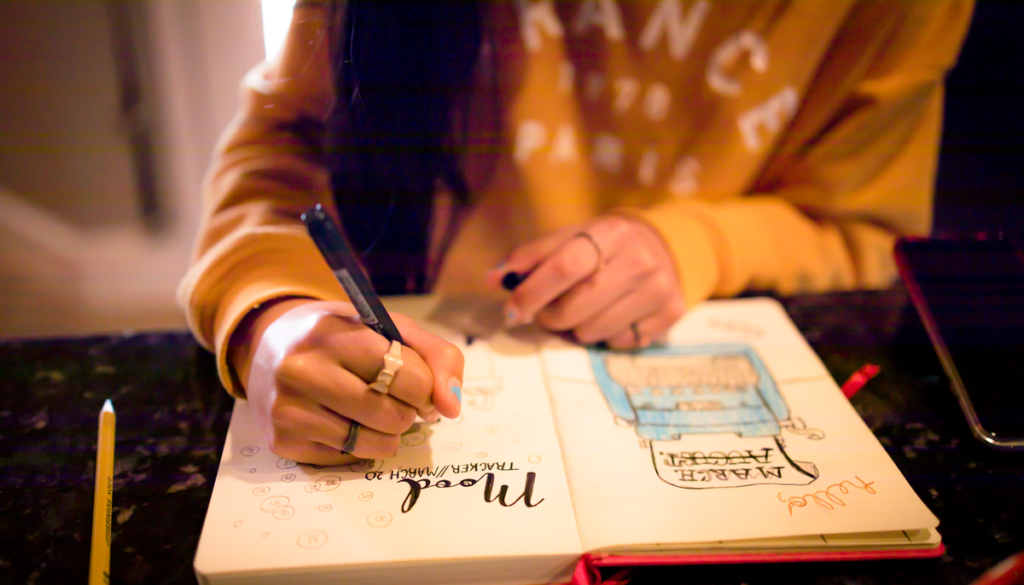 teen at desk doodling in her bullet journal
