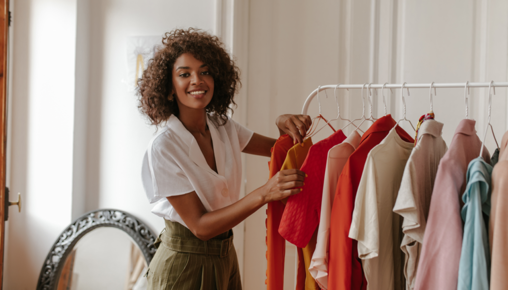 feature image woman smiling in front of her clothing rack