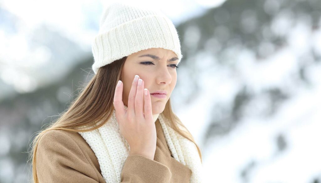 woman touching dry skin on snowy day