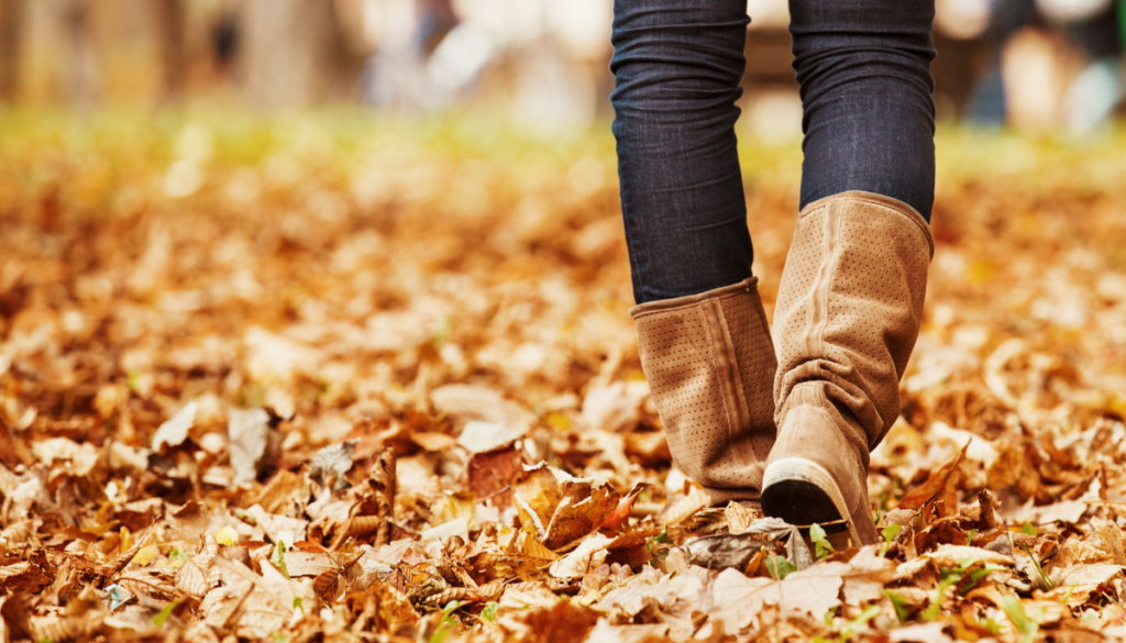 Close up of boots walking through fall leaves