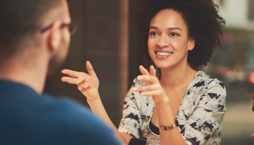 Smiling woman gesturing at man