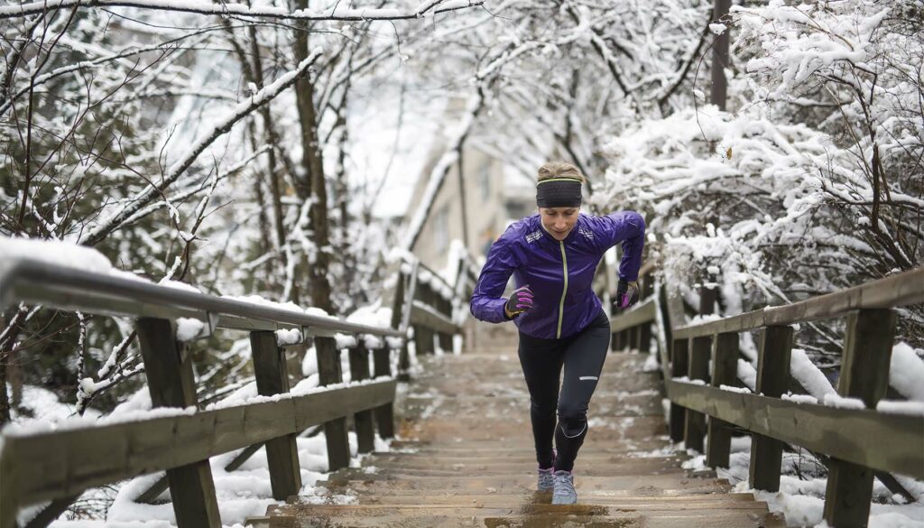 a woman jogging up stairs outdoors in winter season