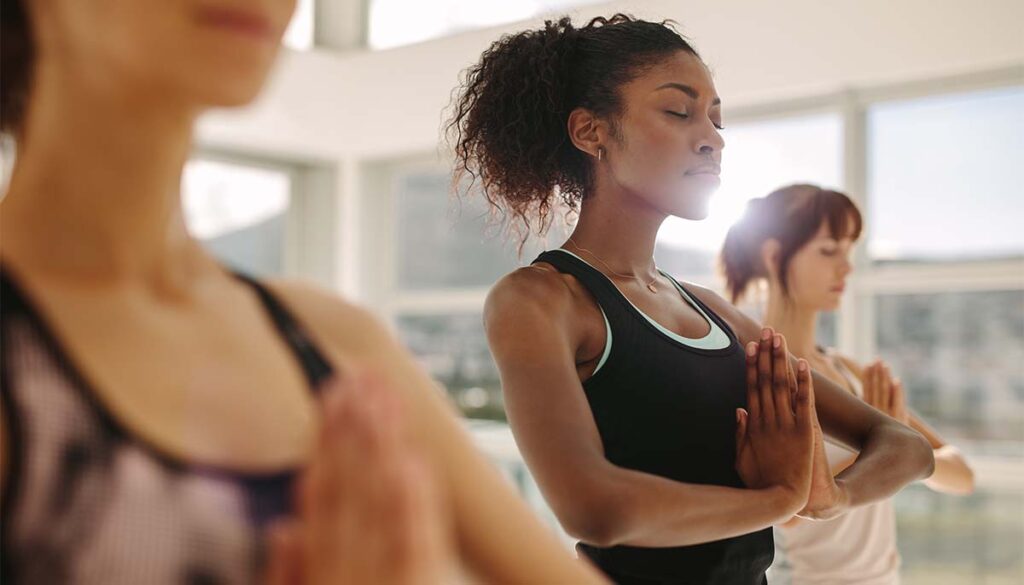 Fit young woman practice yoga with friends.