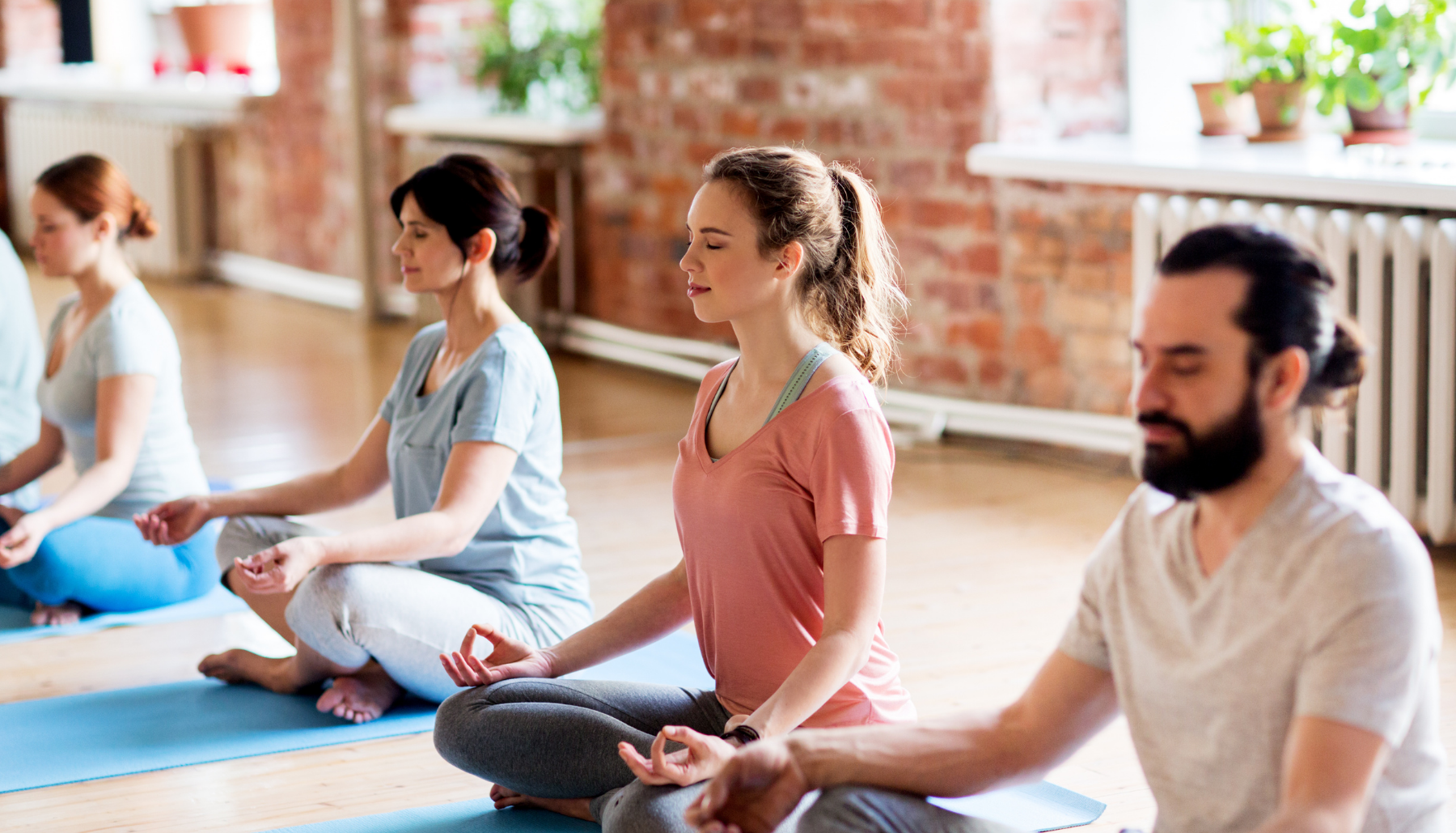 People sitting in lotus position in yoga class