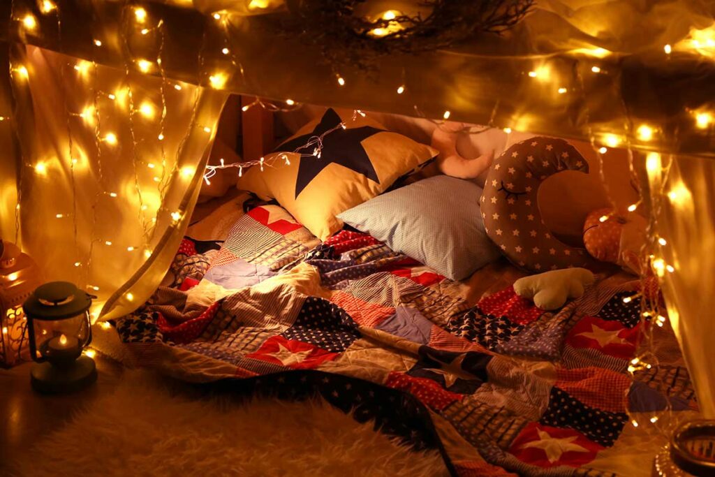 a cozy blanket fort with string lights