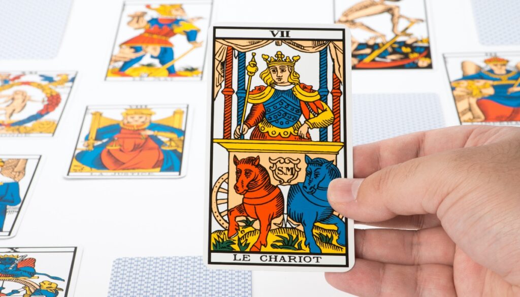a hand holding the chariot card