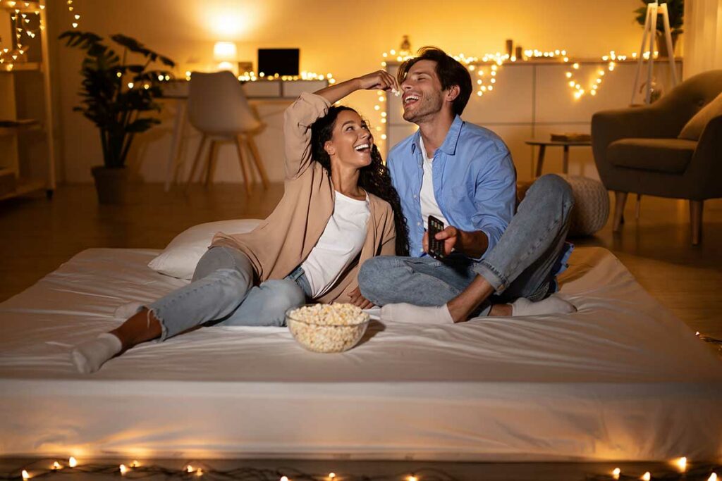 couple having a movie night at home, eating popcorn