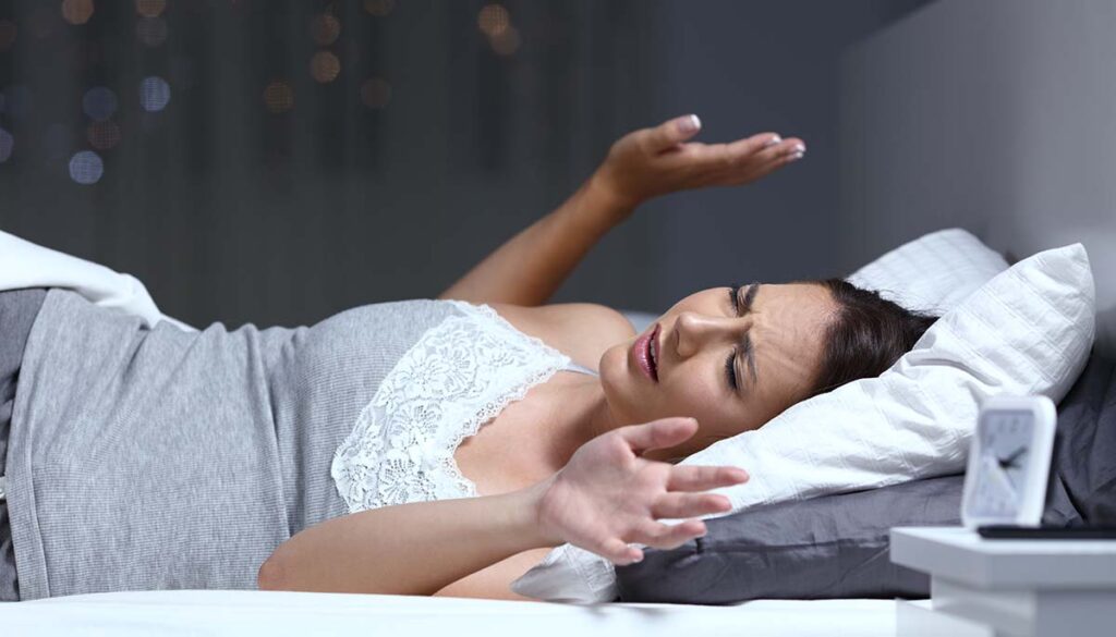 woman having nightmare with hands in the air