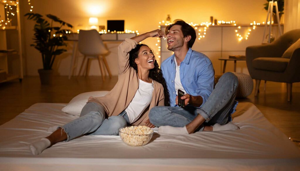 couple having a movie night at home, eating popcorn