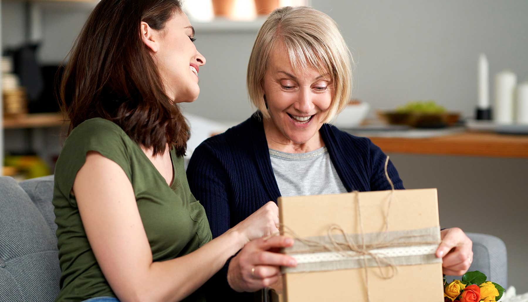 woman opening a gift from her adult daughter