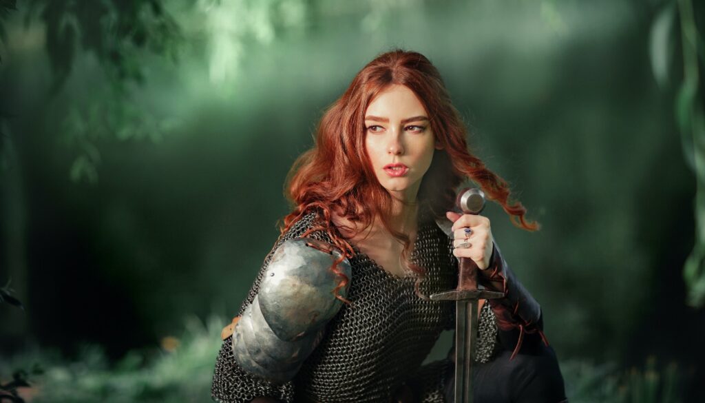 a red head warrior woman holds the hilt of a sword