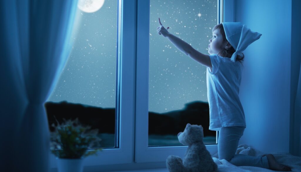 small child pointing up at the full moon