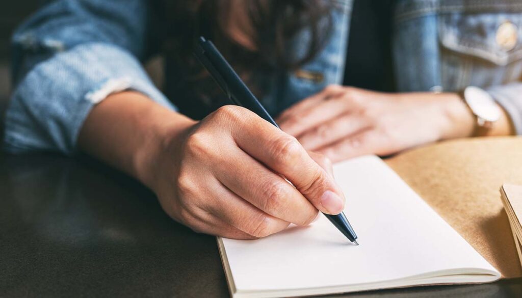 Hands writing in a notebook