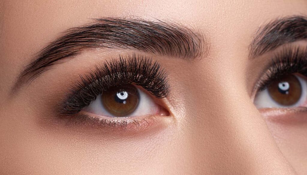 up close photo of woman's eyebrows and brown eyes
