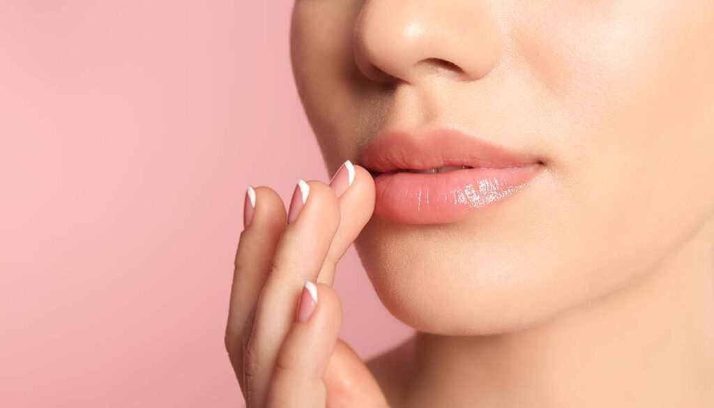 woman touching lips on pink background