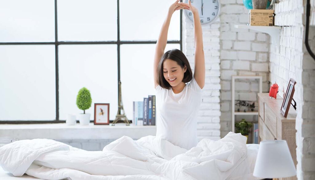 woman doing morning stretch in her bed
