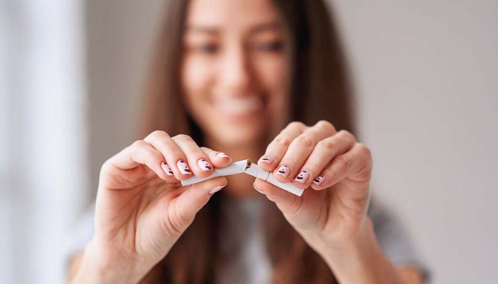 woman breaking cigarette in half