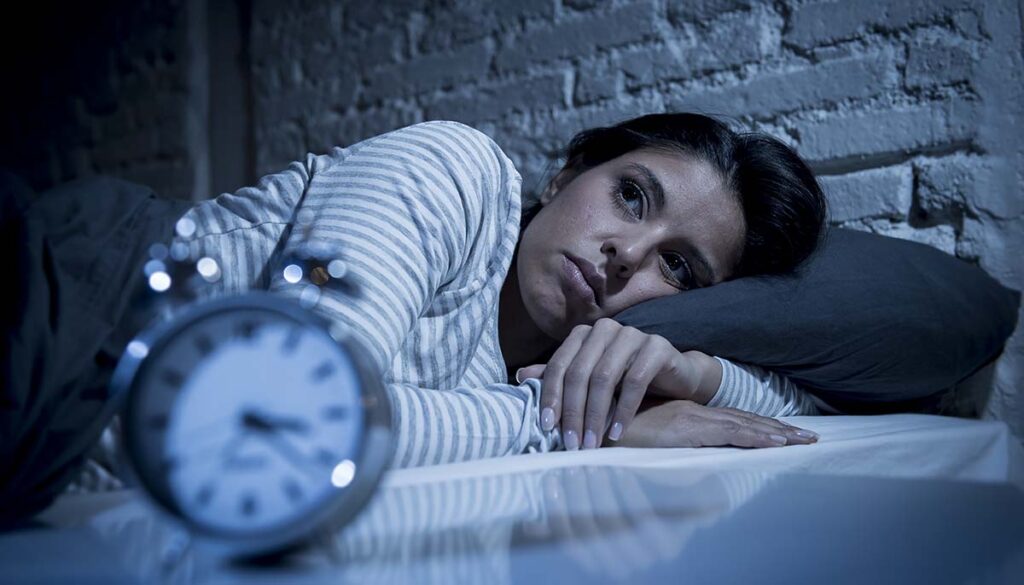 woman unable to sleep being kept awake by intrusive thoughts