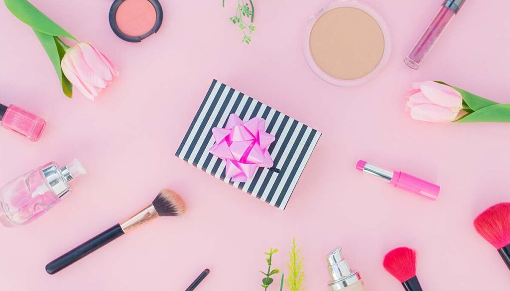 makeup with present in the center on pink background