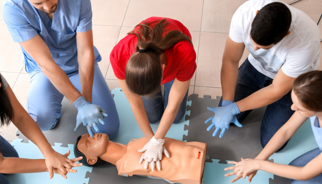 Woman performing CPR on dummy during class