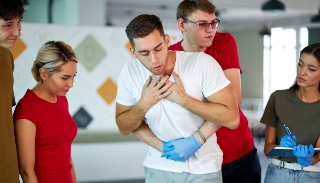 Man giving Heimlich maneuver in first aid class