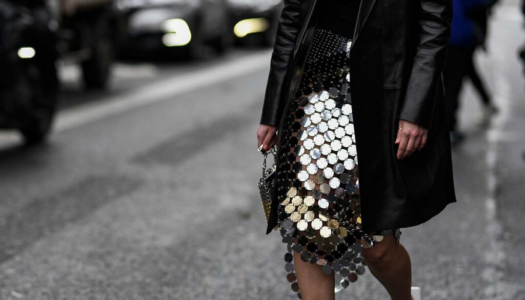 woman in silver sequined skirt crossing the street in NYC during the day