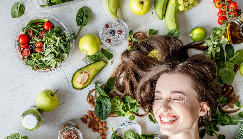 woman with healthy hair surrounded by healthy food