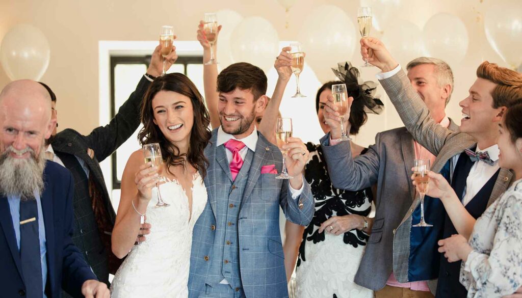 formal wedding, bride and groom with guests holding champagne