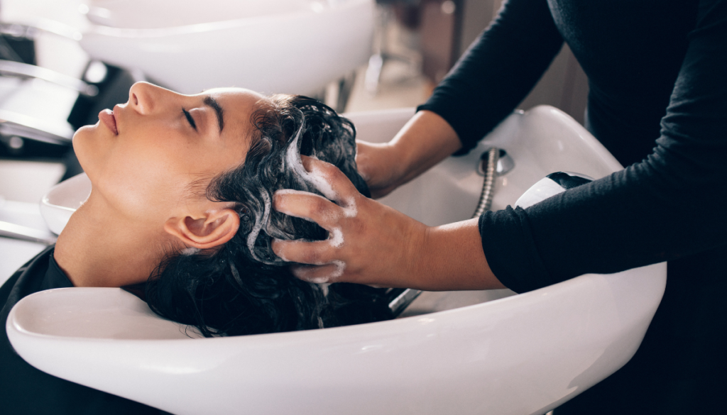 Woman having hair shampooed at salon