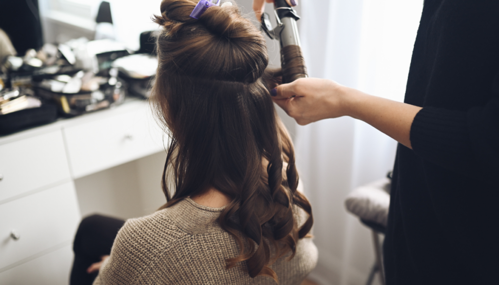 Woman having hair curled at salon